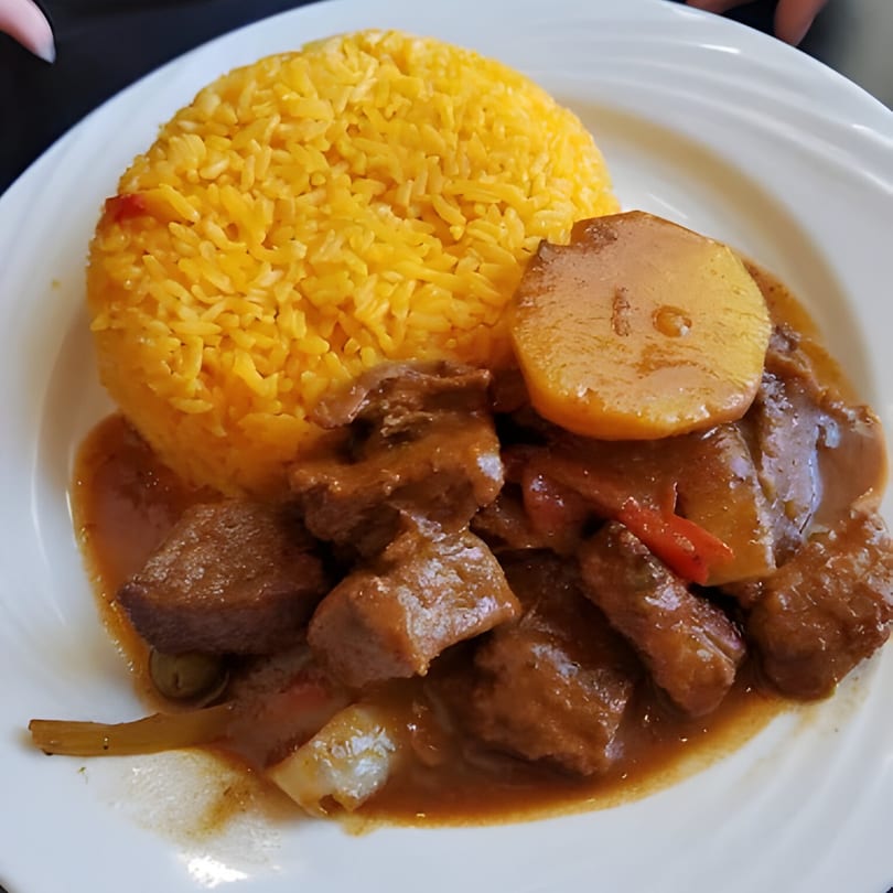 Parrilla Latina's Latin-American dish with yellow rice, beef stew, potatoes, and red peppers.