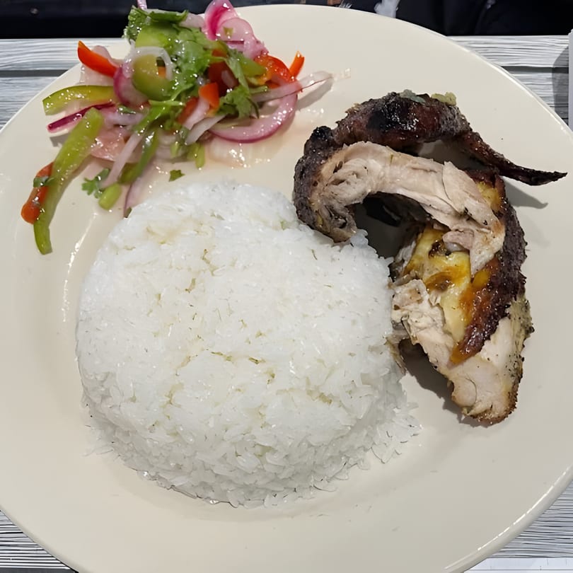 Parrilla Latina's roasted chicken with white rice and a side of fresh vegetable salad.